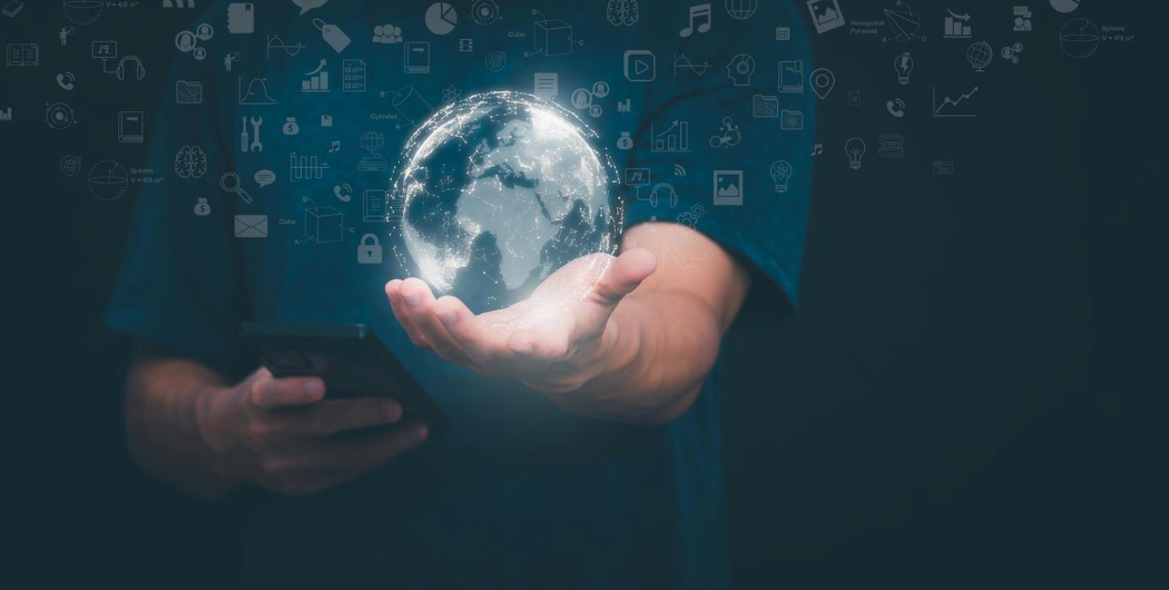 Hand holding a glowing digital globe surrounded by technology icons